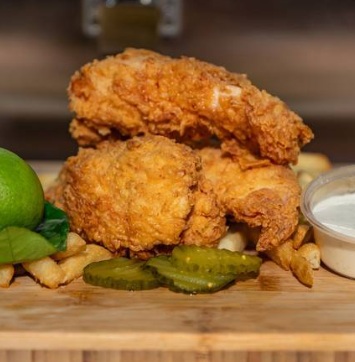 Crispy chicken tenders with fries, pickles, lime and dipping sauce