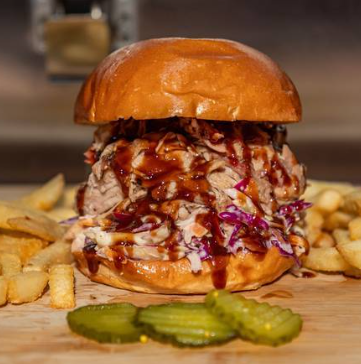 Pulled pork burger with slaw and barbecue sauce, fries and pickles