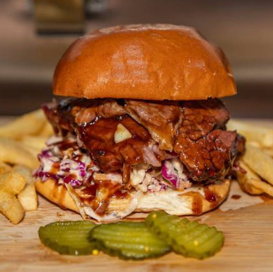 Southwest Barbecue smoked meat burger on a brioche bun with slaw, fries and pickles